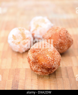 Fried donuts on a wooden plate powdered by sugar. Stock Photo
