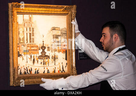 Sotheby's, London, UK. March 21st 2014. A Sotheby's worker hangs one of LS Lowry's two Piccadilly Circus paintings as this and other of his works from the AJ Thompson Collection are exhibited before auction where the works are expected to raise over £15 million. Credit:  Paul Davey/Alamy Live News Stock Photo