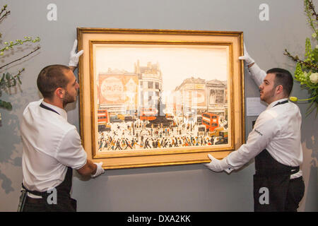Sotheby's, London, UK. March 21st 2014. Sotheby's workers hang LS Lowry's Piccadilly Circus, painted in 1961 and expected to fetch between £4-6 million at auction on March 25th as the AJ Thompson collection, the most comprehensive of Lowry's work, goes on sale. Credit:  Paul Davey/Alamy Live News Stock Photo