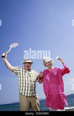 Senior couple on beach with badminton racquet and ball Stock Photo
