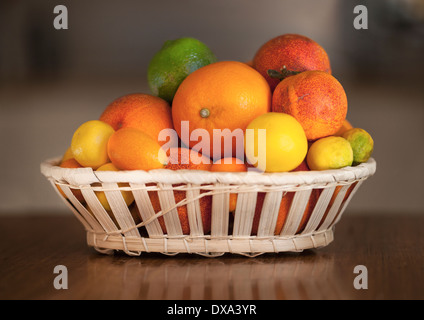 Oranges, limes, t angerines, Chinese oranges, blood oranges and other citrus varieties in a fruit basket. Stock Photo