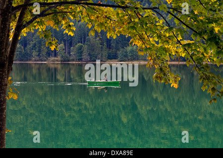 Angler fishing from rowing boat on the Walchensee / Lake Walchen in autumn, Upper Bavaria, Germany Stock Photo
