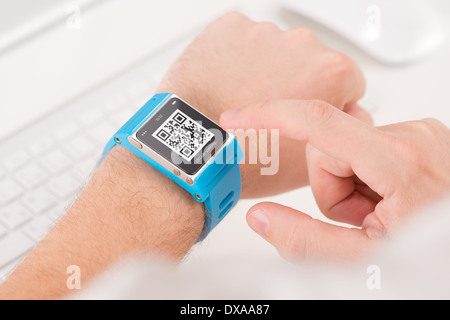 Man is scanning quick response code with blue smart watch Stock Photo
