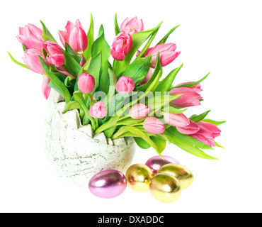beautiful pink tulips in the vase. spring flowers with water drops and shiny easter eggs decoration Stock Photo