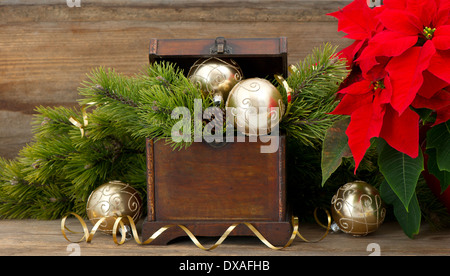 christmas tree brunch with golden decoration, vintage wooden box and red christmas flower poinsettia Stock Photo