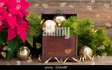 christmas tree brunch with golden decoration, vintage wooden box and pink christmas flower poinsettia Stock Photo