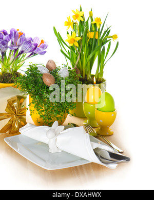 festive easter table setting with eggs and flowers decoration on white background Stock Photo