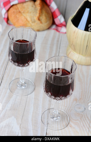 Chianti still life shot from a high angle. Two wineglasses a loaf of bread and Chianti basket bottle. Stock Photo