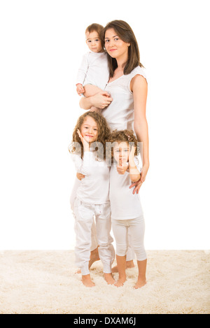 Happy mother with three children posing home and standing on carpet Stock Photo