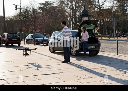 PORTO, PORTUGAL - MARCH 11, 2014: Young technicians using laptop by UAV drone in street Stock Photo
