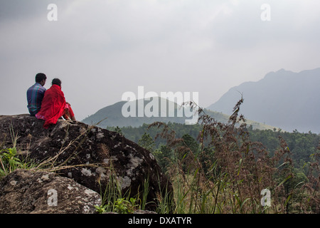 Couple enjoying the mountain view from Ponmudi (Golden Peak) hill station in Kerala, India Stock Photo