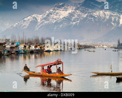 India, Kashmir, Srinagar, shikara carrying passengers from Dal Lake houseboats below Zabarwan mountains Stock Photo