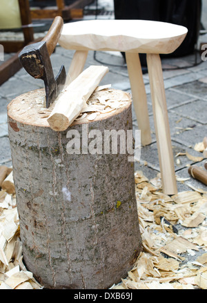 An image of a carpenters work bench, covered in wood shavings, tools, and an axe waitng for its master Stock Photo