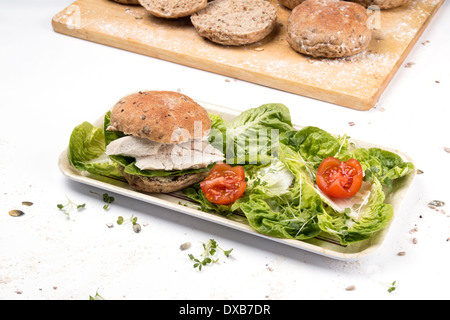 A chicken sandwich made with a seeded brown granary bread bun/cake/bap  on white with tomato cress little Gem salad  (5 of 5) Stock Photo