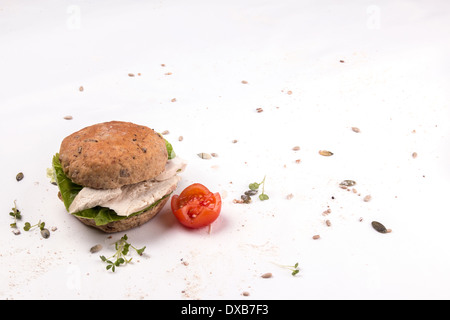 A chicken sandwich made with a seeded granary bread bun/cake/bap  isolated on white with tomato and cress garnish (1 of 5) Stock Photo