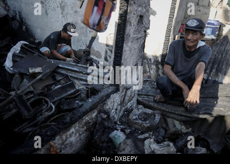 Caloocan, Philippines. 23rd Mar, 2014. Residents sift through rubble of burnt shanties after a fire gutted a residential area in Caloocan city, north of Manila, Philippines, March 23, 2014. At least 1700 families have been left homeless after 3 separate fires gutted 700 homes in a span of 24 hours. The fires took place as the country observes Fire Prevention Month.Photo: Ezra Acayan/NurPhoto Credit:  Ezra Acayan/NurPhoto/ZUMAPRESS.com/Alamy Live News Stock Photo