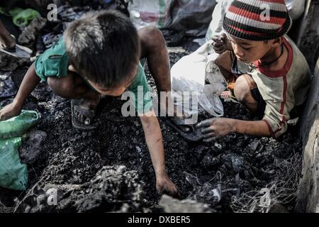 Caloocan, Philippines. 23rd Mar, 2014. Children sift through rubble for scrap metal after a fire gutted a residential area in Caloocan city, north of Manila, Philippines, March 23, 2014. At least 1700 families have been left homeless after 3 separate fires gutted 700 homes in a span of 24 hours. The fires took place as the country observes Fire Prevention Month.Photo: Ezra Acayan/NurPhoto Credit:  Ezra Acayan/NurPhoto/ZUMAPRESS.com/Alamy Live News Stock Photo