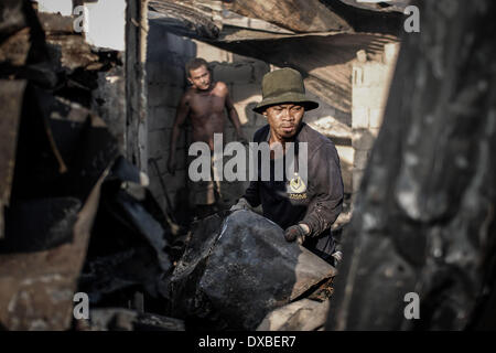 Caloocan, Philippines. 23rd Mar, 2014. Residents collect scrap metal from burnt shanties after a fire gutted a residential area in Caloocan city, north of Manila, Philippines, March 23, 2014. At least 1700 families have been left homeless after 3 separate fires gutted 700 homes in a span of 24 hours. The fires took place as the country observes Fire Prevention Month.Photo: Ezra Acayan/NurPhoto Credit:  Ezra Acayan/NurPhoto/ZUMAPRESS.com/Alamy Live News Stock Photo