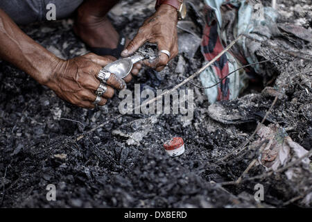 Caloocan, Philippines. 23rd Mar, 2014. A resident recovers an ice cream scoop from rubble after a fire gutted a residential area in Caloocan city, north of Manila, Philippines, March 23, 2014. At least 1700 families have been left homeless after 3 separate fires gutted 700 homes in a span of 24 hours. The fires took place as the country observes Fire Prevention Month.Photo: Ezra Acayan/NurPhoto Credit:  Ezra Acayan/NurPhoto/ZUMAPRESS.com/Alamy Live News Stock Photo