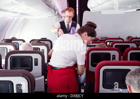 Virgin Atlantic cabin crew air stewardess at work in the plane aircraft cabin on a Dubai to London flight Stock Photo