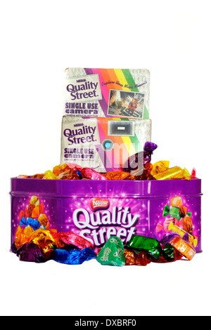 tin of quality street chocolates with an old disposal camera given away as a free promotion Stock Photo