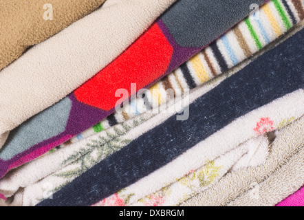 stack of worn towels of various colours and patterns Stock Photo