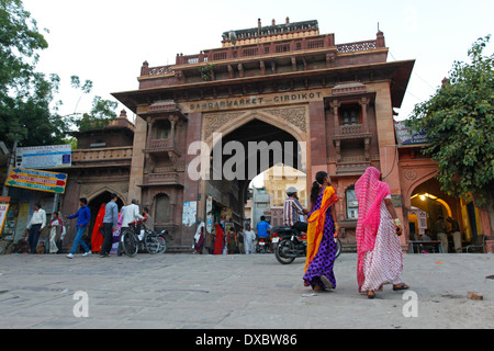 Two women with saris in front of the 'Sandar market' entrance. Jodhpur, Rajasthan, India. Stock Photo