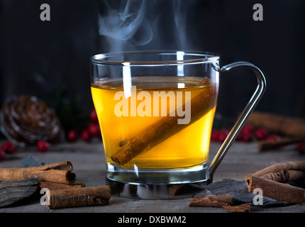 Hot whiskey, rum, apple or brandy toddy cocktail drink with cinnamon set on rustic wood Stock Photo