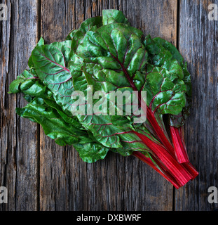 Organic red ruby swiss chard raw on rustic wood Stock Photo