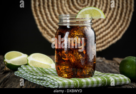 Cuba Libre or rum and cola drink with ice and lime in mason jar Stock Photo
