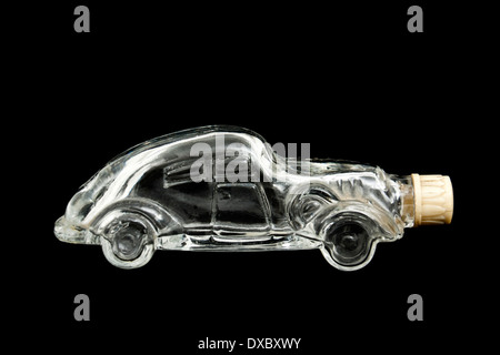 Vintage car-shaped empty perfume bottle against black background Stock Photo