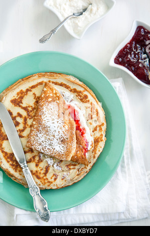 Crepes with cream cheese and strawberry jam. Stock Photo