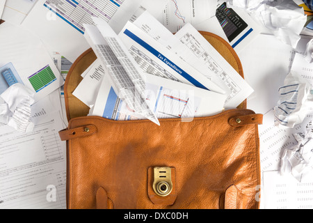 Concept photo showing briefcase open and overflowing with paperwork which can be used with tax or other financial stories Stock Photo