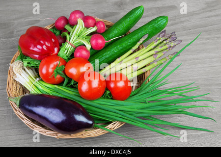 Fresh organic vegetables in a basket on wooden vintage table Stock Photo