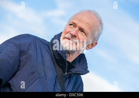 Low angle view of an attractive bearded senior man with a thoughtful expression staring off to the left of the frame Stock Photo