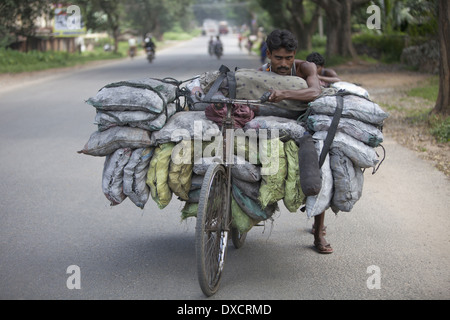 A tribal man carrying coals from village to town on bicycle. Munda tribe. Bariatu near Ranchi District Jharkhand, India Stock Photo