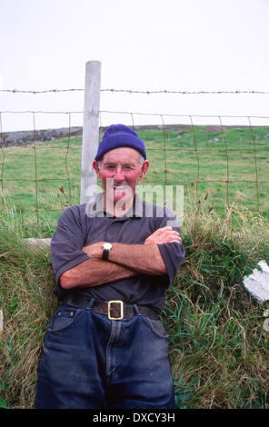 Farmer leaning against a grassy stone wall, near Dursey Head, Beara Peninsula, County Cork, Ireland Stock Photo