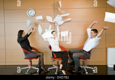 Office workers throwing documents up in the air Stock Photo