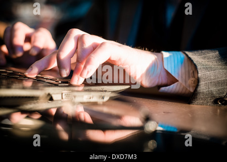 close up of hands typing on notebook in a table Stock Photo