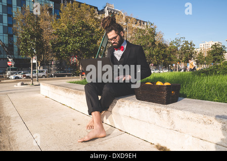 Stylish elegant dreadlocks businessman using notebook in business landscape Stock Photo
