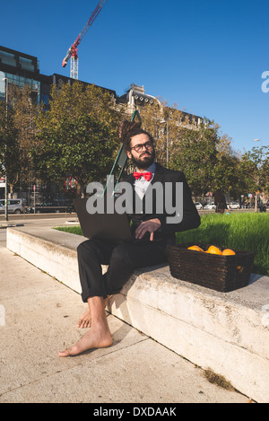 Stylish elegant dreadlocks businessman using notebook in business landscape Stock Photo