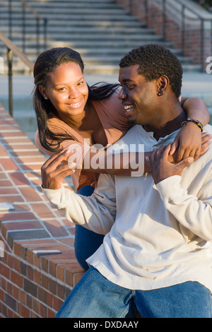 Young couple embracing outdoors on college campus, young woman smiling and looking at camera, Florida, USA Stock Photo