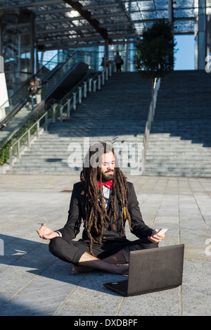 Stylish elegant dreadlocks businessman using notebook in business landscape Stock Photo