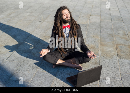 Stylish elegant dreadlocks businessman using notebook in business landscape Stock Photo