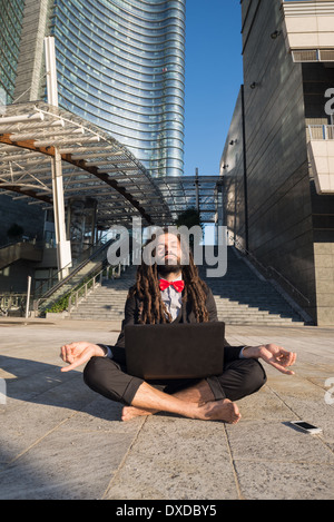 Stylish elegant dreadlocks businessman using notebook in business landscape Stock Photo