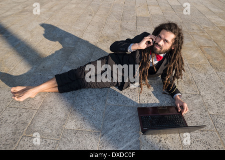 Stylish elegant dreadlocks businessman using notebook in business landscape Stock Photo