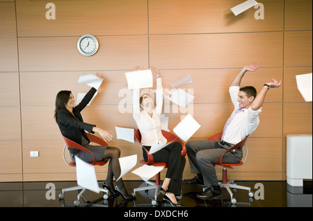 Office workers throwing documents up in the air Stock Photo