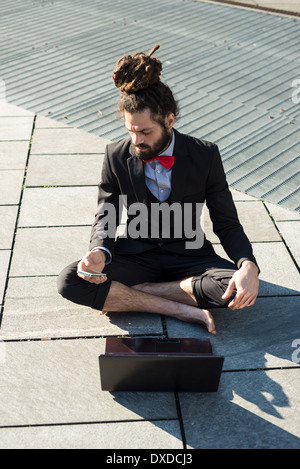 Stylish elegant dreadlocks businessman using notebook in business landscape Stock Photo