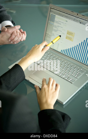 Business people's hands with laptop showing bar chart Stock Photo