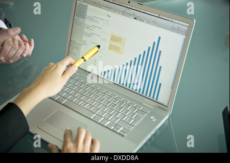Business people's hands with laptop showing bar chart Stock Photo